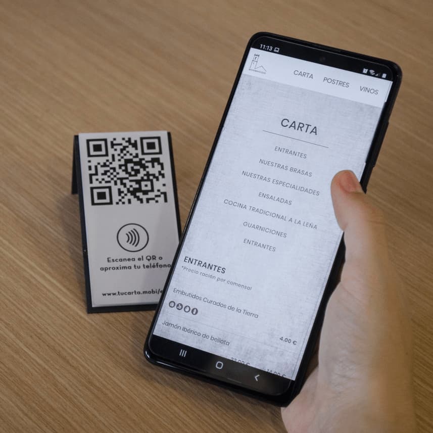 Cartas digitales del restaurante Elias en el móvil junto a la peana con la tecnología QR