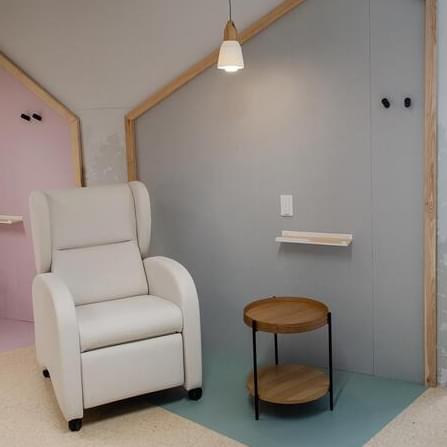 Espacio con sillón y mesita de la casita azul. Diseño de interiores de la Fundación Aladina, proyecto de IDEADE