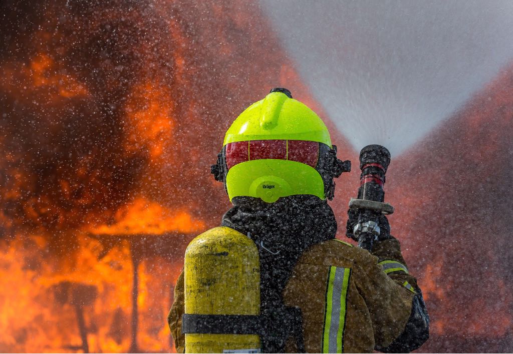 Imagen de un bombero apagando un fuego.