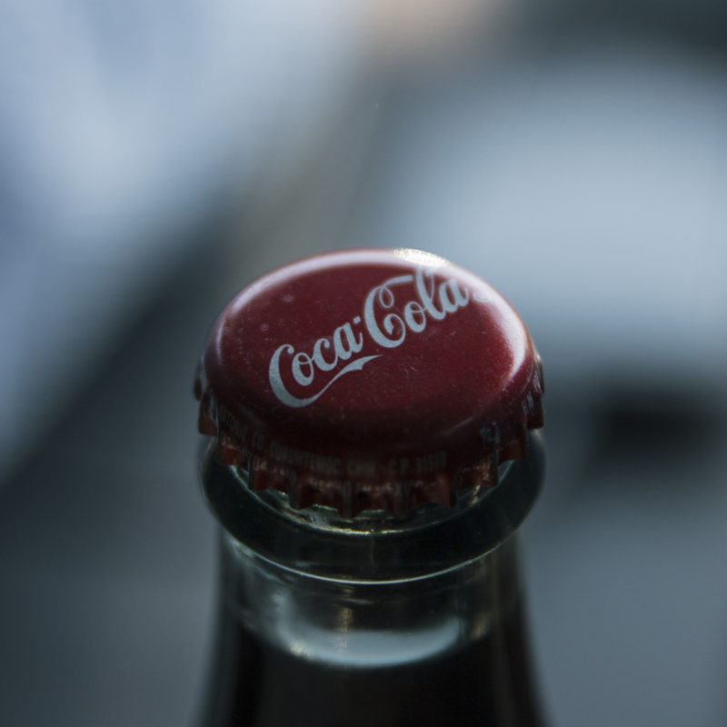 Imagen del logo de Coca-Cola sobre una chapa de una botella.